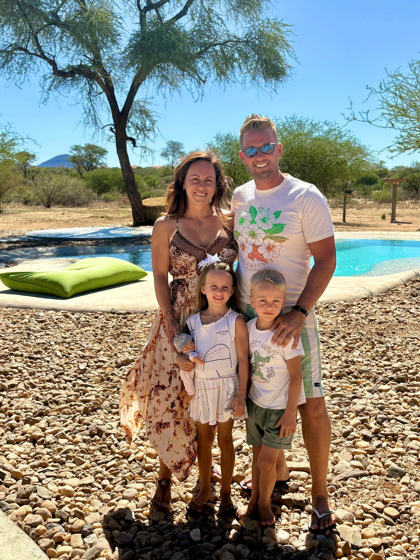 Familienfoto unter dem Kameldornbaum neben dem Pool